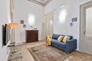 a living room with a blue couch and a television at Apartments to Art in Turin