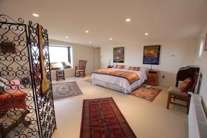 a bedroom with a bed and a chair and a window at Appelgren House Hotel Boutique in Puerto Natales