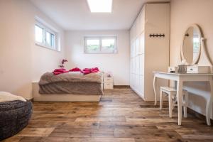 una camera con letto, tavolo e specchio di Moderne Souterrain-Wohnung ad Anif