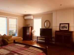 a living room with a couch and a television at Seaview White House in Stratford