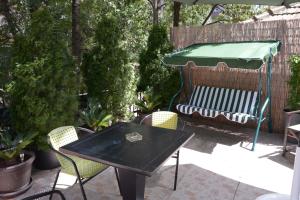 a patio with a table and chairs and a green umbrella at Guest House GOLDEN COIN in Niš