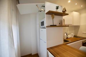 una pequeña cocina con nevera blanca y encimera en Sky - Studio au centre du Pas de la Case, rénové et charmant, en Pas de la Casa