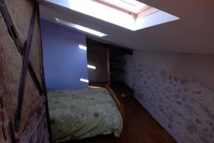 1 dormitorio pequeño con 1 cama y tragaluz en Gîte fermier de Saint-Lizier, en Saint-Lizier