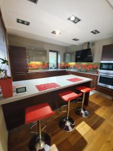 eine Küche mit einer großen Insel mit roten Barhockern in der Unterkunft Villa ENERGY in Zator