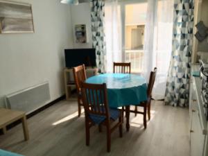 comedor con mesa azul y sillas en APPARTEMENT RDC 4 PERS A 100 M DE LA MER, en Fort-Mahon-Plage