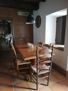 a dining room with a wooden table and chairs at Casa Rural El Enebro in Navamorcuende