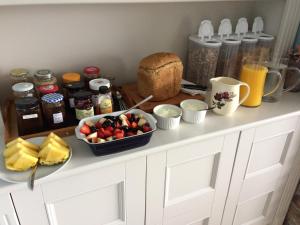 a kitchen counter with a bowl of fruit and a plate of bread at Robins Nest in Ardara