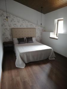 1 dormitorio con cama y ventana. en Casa Rural El Enebro, en Navamorcuende