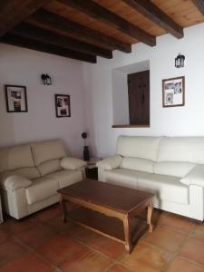 a living room with two couches and a coffee table at Casa Rural El Enebro in Navamorcuende