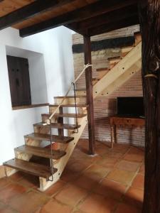 escalera de madera en una habitación con mesa en Casa Rural El Enebro, en Navamorcuende