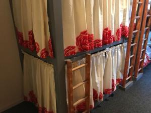 a row of red umbrellas hanging from a wall at The Birds Nest Hostel in London