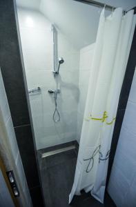 La salle de bains est pourvue d'une douche avec rideau de douche. dans l'établissement Rooms pr zajčku, à Tolmin