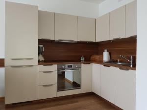 eine Küche mit weißen Schränken und Küchengeräten aus Edelstahl in der Unterkunft Apartament w Pobliżu Morza 2 in Kołobrzeg