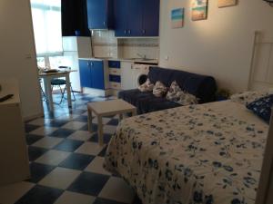 sypialnia z łóżkiem i kanapą oraz kuchnia w obiekcie M3 904 Azul Mediterráneo bonito y confortable estudio w mieście Benalmádena +37 zdjęć