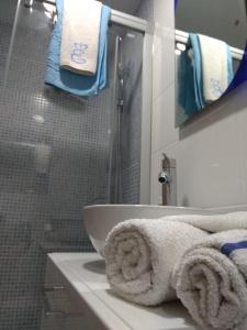 W łazience znajduje się umywalka oraz prysznic z ręcznikami. w obiekcie M3 904 Azul Mediterráneo bonito y confortable estudio w mieście Benalmádena