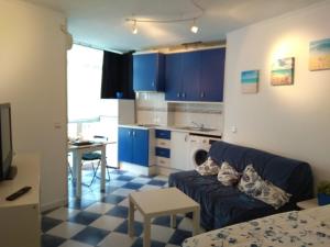 salon z niebieską kanapą i kuchnią w obiekcie M3 904 Azul Mediterráneo bonito y confortable estudio w mieście Benalmádena