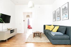 a living room with a blue couch and a table at Be in Berlin Apartments in Prenzlauer Berg in Berlin