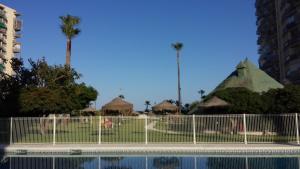 ogrodzenie obok basenu z palmami w obiekcie M3 904 Azul Mediterráneo bonito y confortable estudio w mieście Benalmádena