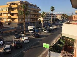 a busy city street with cars and palm trees at B&B Le Meduse in Fiumicino