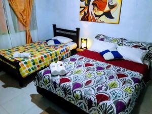 two beds sitting next to each other in a room at Vivienda Turistica Yerbabuena in Filandia