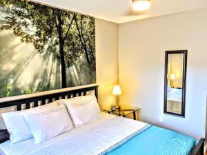 a bedroom with a bed with a large painting on the wall at Downtown Loft Oasis in Columbus