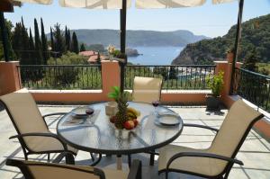 uma mesa com uma taça de fruta e copos de vinho em Thalassa Studios em Paleokastritsa