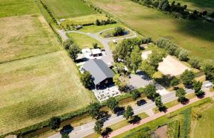 een bovengronds uitzicht op een gebouw met een weg en bomen bij De la Rue Pipowagens in Sleeuwijk