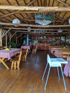 une salle à manger avec des tables et des chaises dans un restaurant dans l'établissement Camping Robinson Country Club Oradea, à Oradea