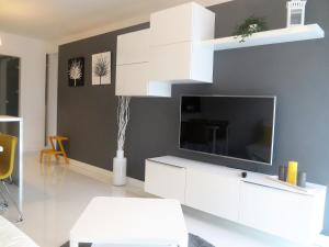 a living room with a tv and a white entertainment center at Apartament Maxi in Poznań
