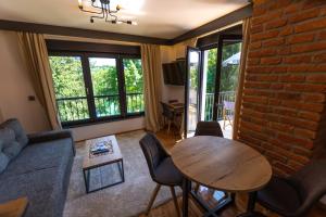 a living room with a table and a brick wall at Pampas apartments Mrežnica in Duga Resa