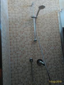 een douche in een badkamer met een betegelde muur bij Pisa apartment in Pisa
