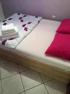 a bed with white sheets and red flowers on it at Amazing View Pirano in Piran