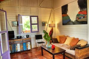 a living room with a couch and a table at Villa Deshaies in Deshaies