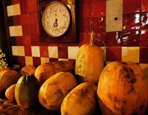 a pile of pumpkins sitting next to a clock at Hotel Restaurant Bujtina e Gjelit in Tirana