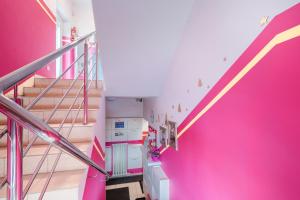 a room with a pink wall and stairs at Pokoje Goscinne Oliwia & Laura I in Rumia