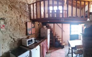 a kitchen with a microwave and a staircase in a room at Comenda da Povoa in Tomar
