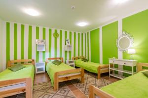 a green room with two beds and a mirror at Pokoje Goscinne Oliwia & Laura II in Rumia