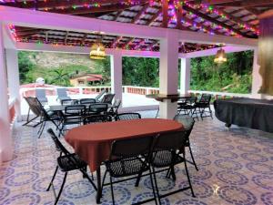 a patio with a table and chairs and lights at Polish Princess Guest House in Port Antonio