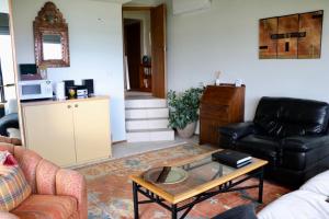 a living room with two couches and a coffee table at Titore Lodge in Russell