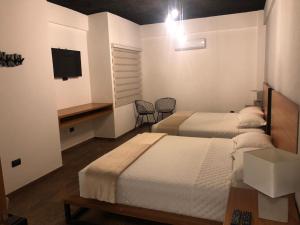 a hotel room with two beds and a television at Sibaris cañoto in Santa Cruz de la Sierra