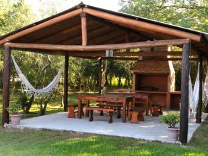 un pabellón de madera con una mesa de picnic en un parque en Posada Che Teindy en Colonia Carlos Pellegrini
