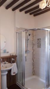 ein Bad mit einer Dusche und einem Waschbecken in der Unterkunft La Maison Bourgeoise in Saint-Priest-des-Champs