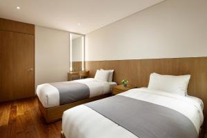 a hotel room with two beds with white sheets at Lotte Resort Sokcho in Sokcho
