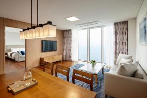 a living room with a couch and a dining room at Lotte Resort Sokcho in Sokcho