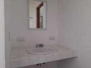 a white bathroom with a sink and a mirror at Centro Ecoturistico Ya´ajche in Lacanjá