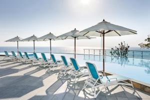 a row of chairs and umbrellas next to a swimming pool at Lotte Resort Sokcho in Sokcho
