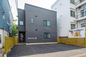 um edifício com um sinal na lateral em Stay Asahikawa Koto em Asahikawa