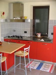 een keuken met rode kasten en een tafel met stoelen bij La Miseria in Ovada