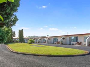 una fila de casas con un césped verde delante en ASURE Oakleigh Motel, en Gore