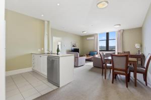 a kitchen and living room with a table and chairs at Launceston Central Apartment Hotel Official in Launceston